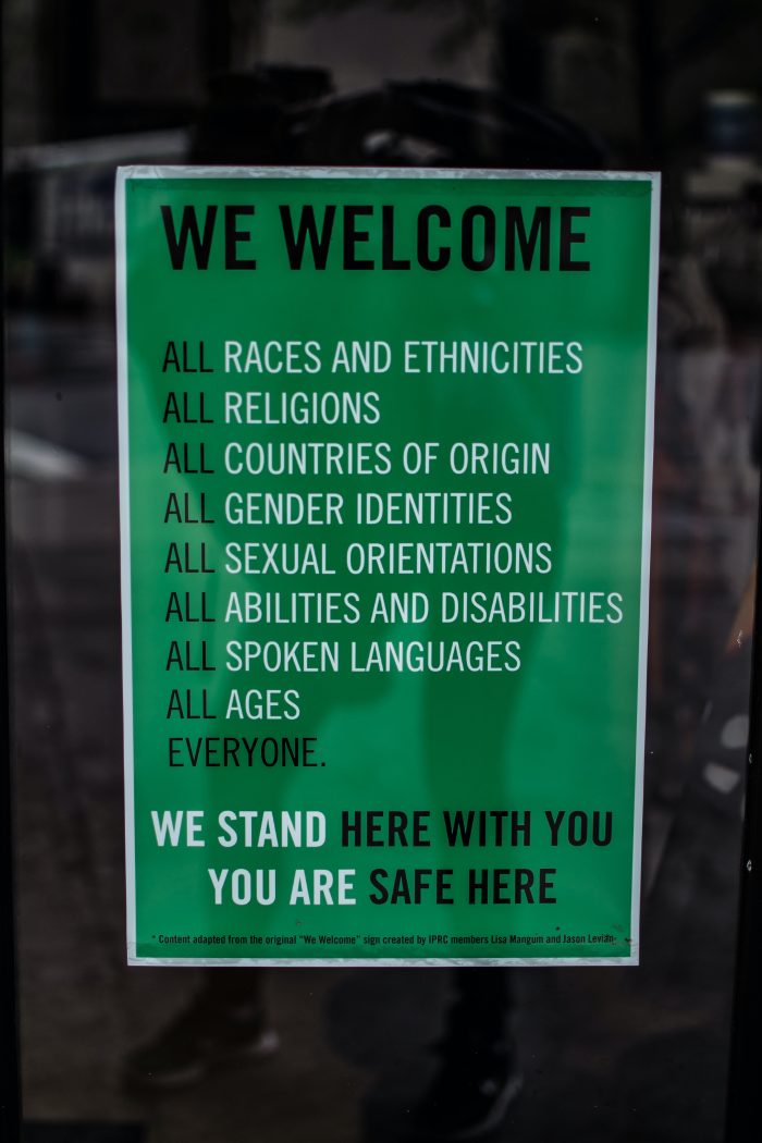 Poster saying: We Welcome all races and ethnicities, all religions, all countries of origin, all gender identities, all sexual orientations, al abilities and disabilities, all spoken languages, all ages. Everyone. We stand here with you. You are safe here.
