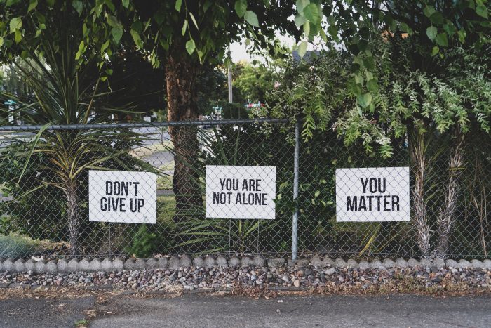 Signs on a fence saying Dont Give Up, You Are Not Alone, You Matter